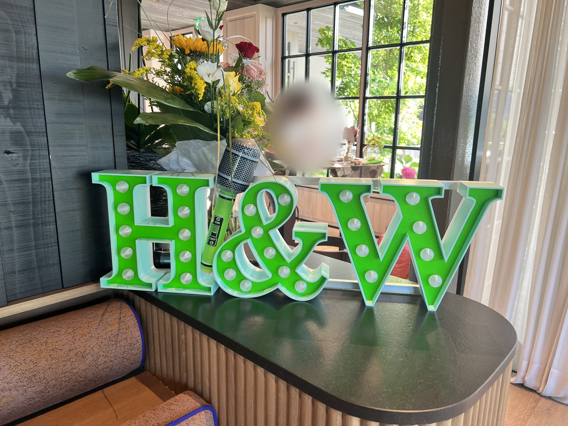 H&W marquee letters with bulbs on a bar counter at a wedding party