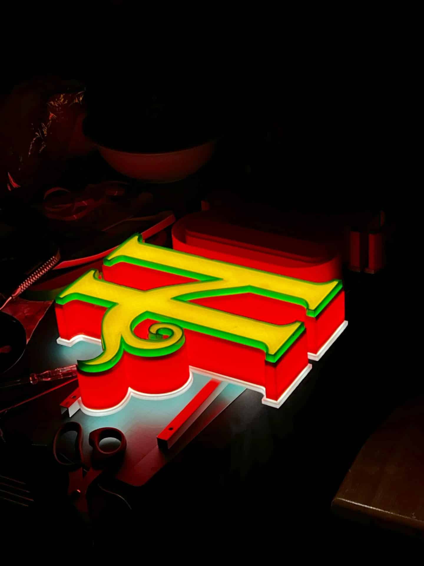 First lit letter of the HOBLÍK sign in the workshop